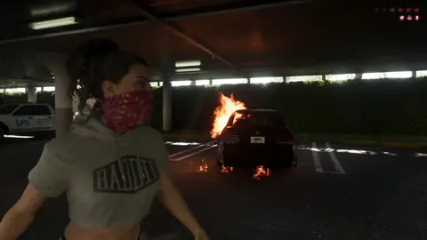 Lucia in a bandana beside a burning car in a parking garage, from the GTA 6 Extended Look