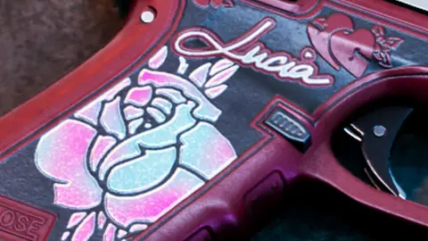Close-up of the painted grip on Lucia's Klose K17 with the rose and her name in script