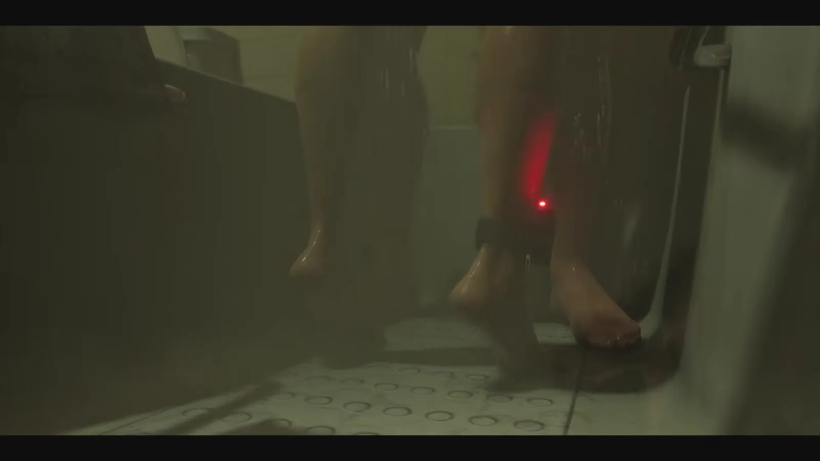 Eine Fußfessel mit rotem Licht an einem Knöchel unter der Dusche, aus dem GTA 6 Launch Trailer