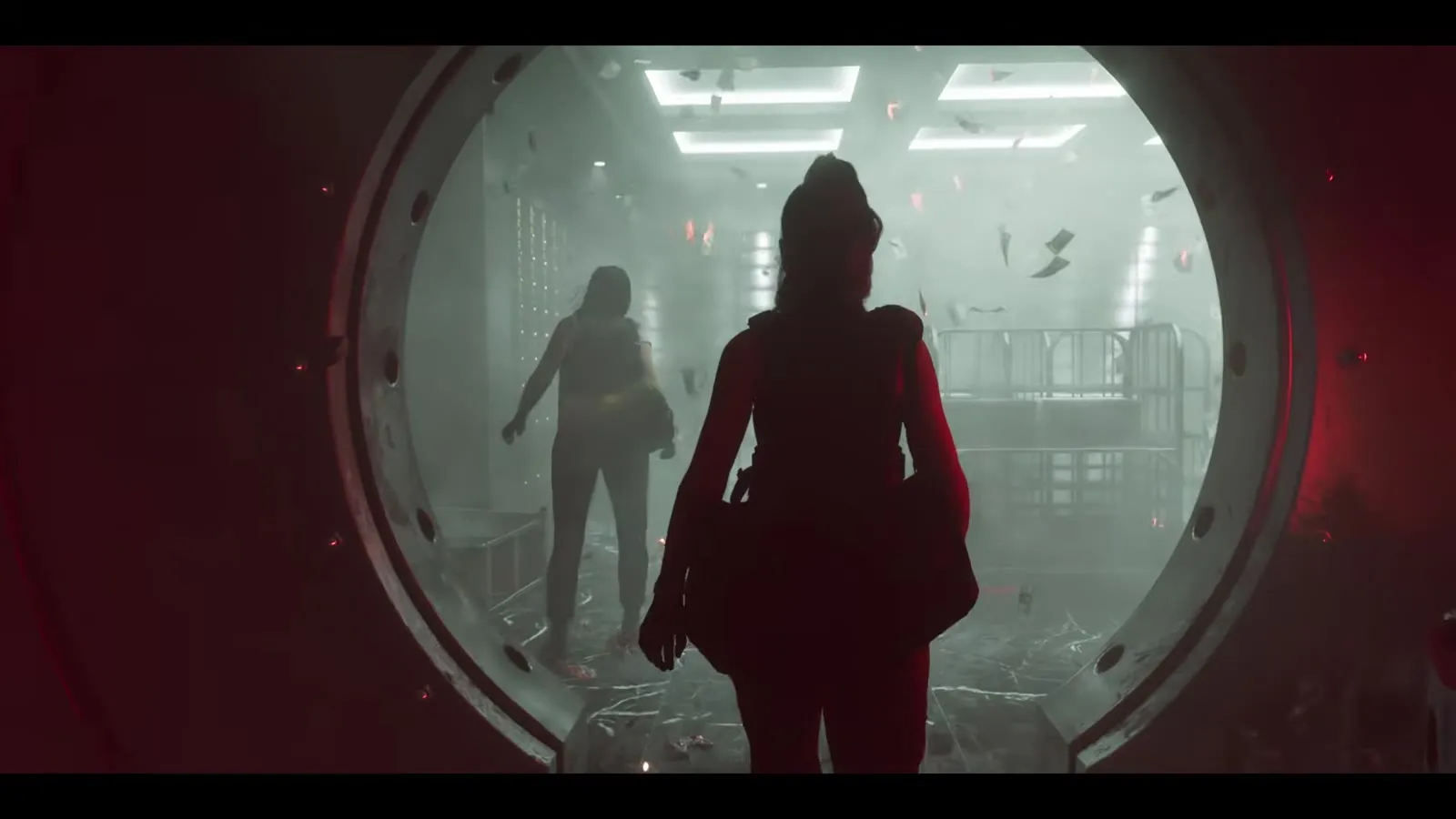 Zwei Gestalten gehen durch die runde Tresortür einer Bank, Geldscheine fliegen durch die Luft, aus dem GTA 6 Launch Trailer