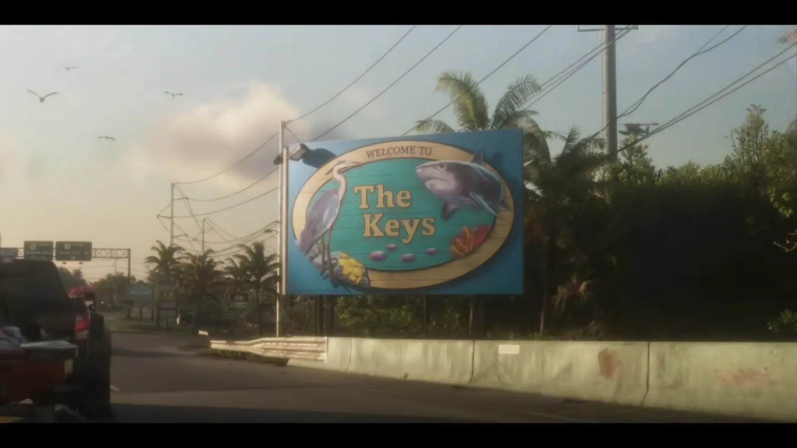 Ein Pick-up mit einem Jetski im Schlepp fährt am Schild Welcome to The Keys vorbei, aus dem GTA 6 Launch Trailer