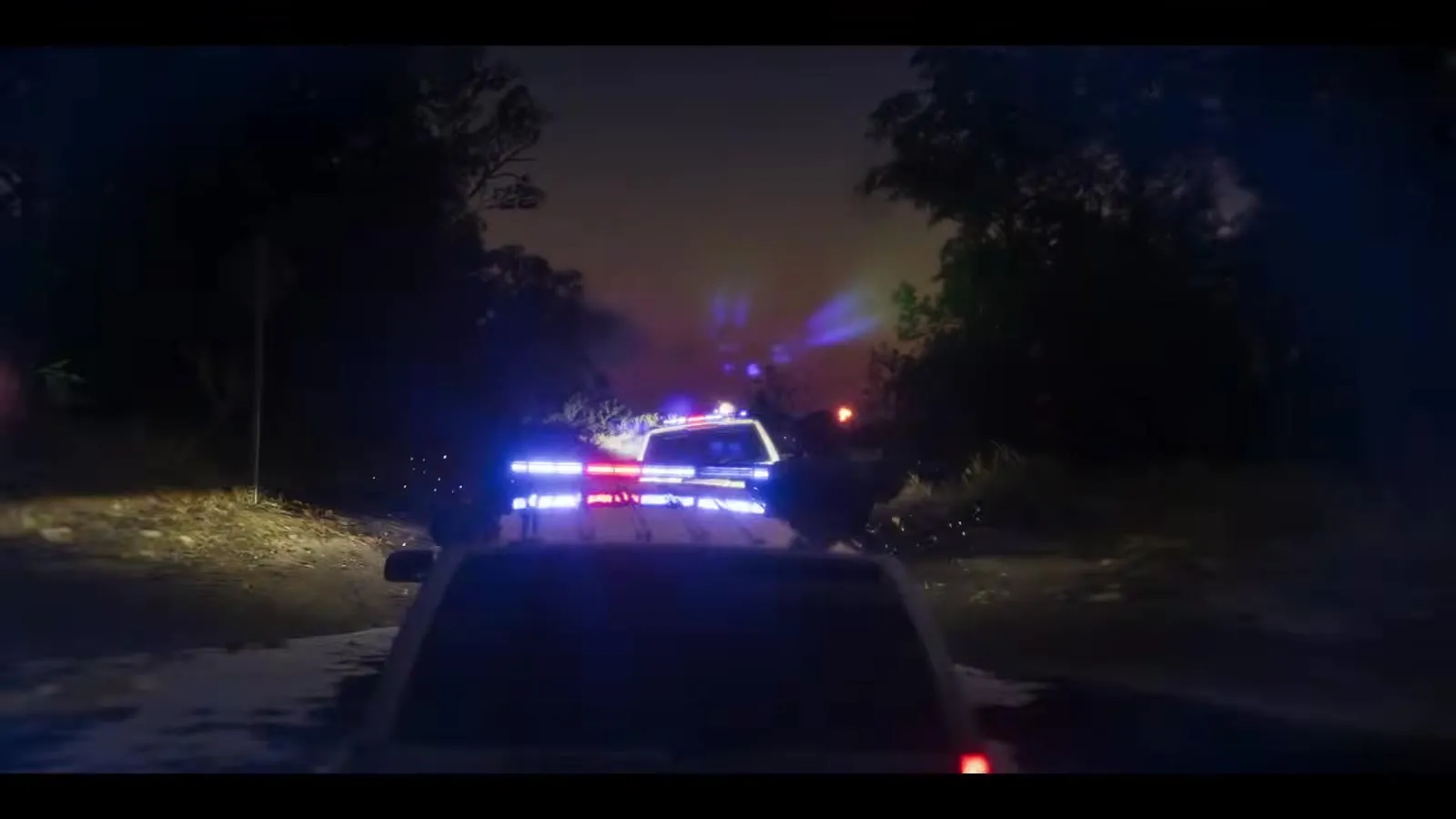 Jason zielt mit einem Zielfernrohrgewehr, hinter ihm die beleuchtete Stadt, aus dem GTA 6 Launch Trailer
