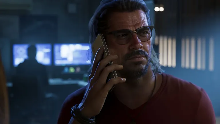 Raul Bautista official artwork from the GTA VI website - Raul holding a phone to his ear, a person at two computer monitors behind him